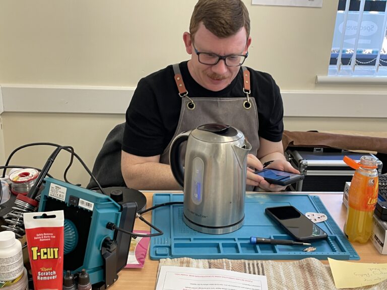 A repairer fixes a kettle